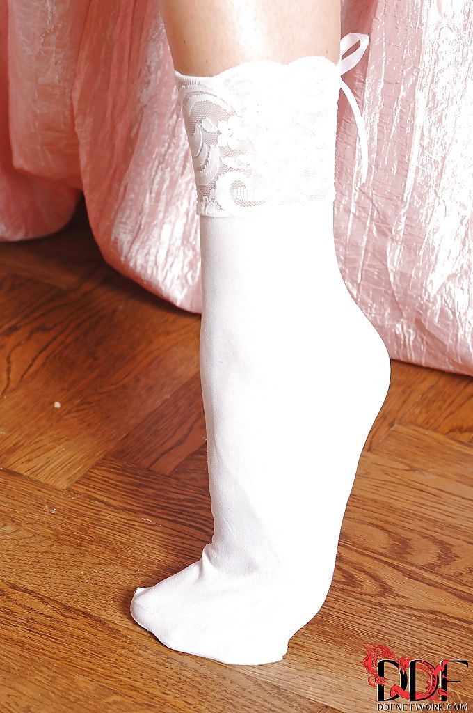 Wenselijk meisje in lingerie en wit sokken onthulling haar curves en sexy Voeten