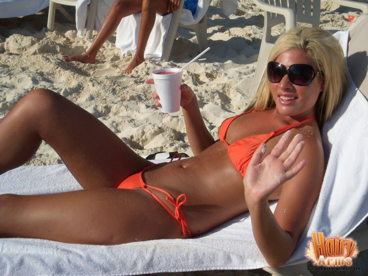 hirsute Loira Lori anderson relaxa no um Praia no ela biquini e óculos de sol