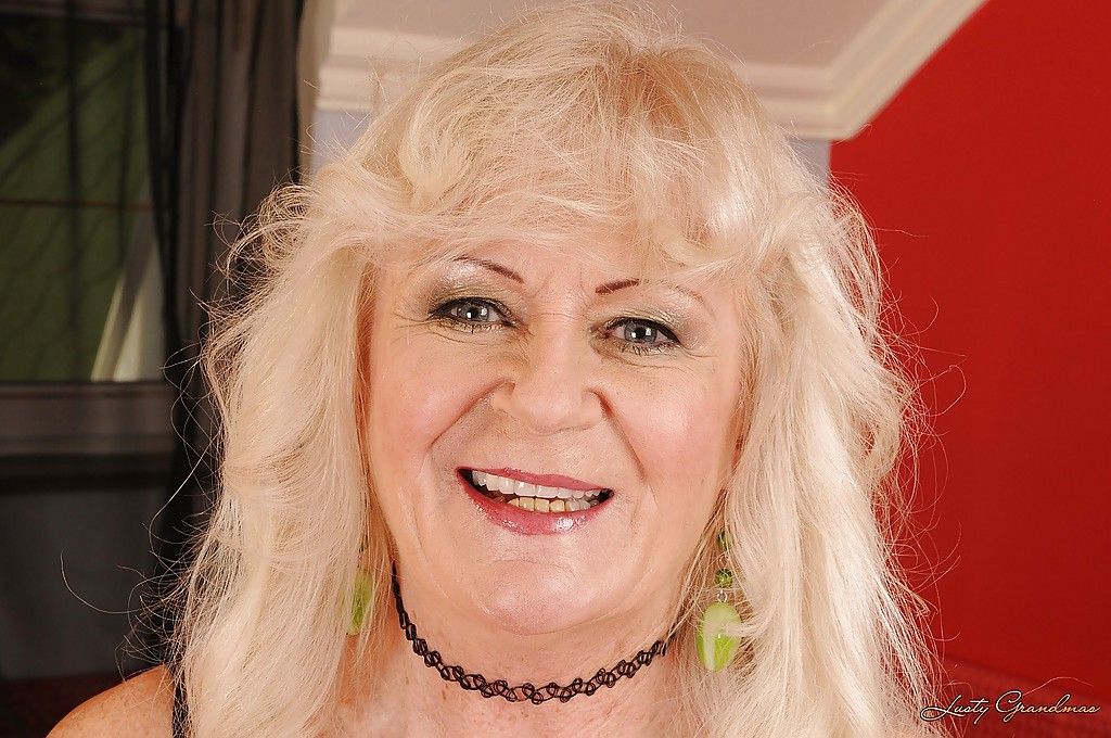 Blond Oma in kousen strippen en poseren naakt op De Bed