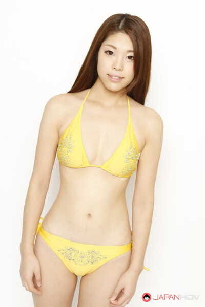 Young Japanese redhead models a yellow bikini in a safe for shoot