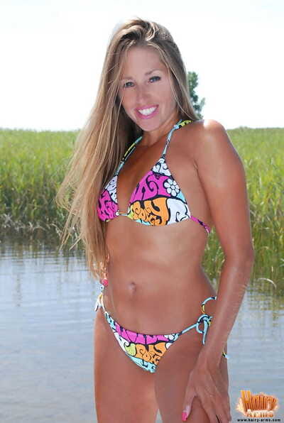 Petite blonde Lori Anderson peels off her bikini in front of a marsh