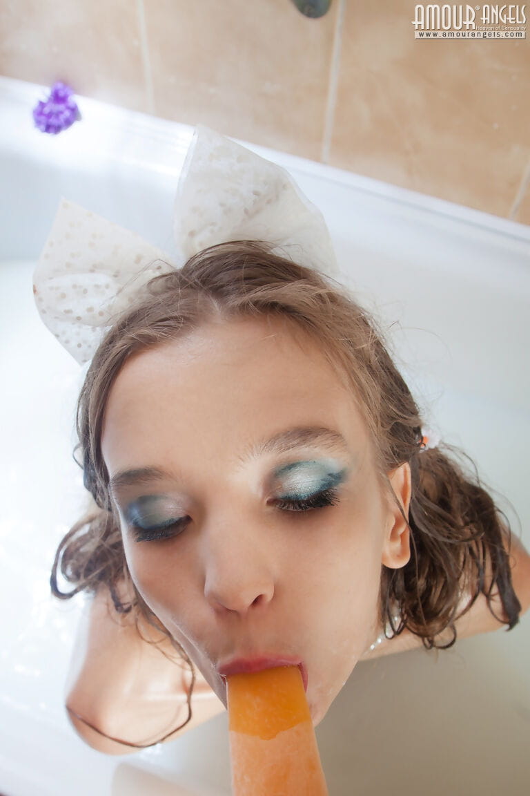 Tiny teen girl Alisabelle pours milk over her naked body while taking a bath
