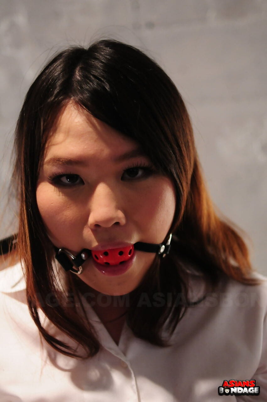 Asian chick Aki Sasahara is fitted with gag in white blouse and black skirt