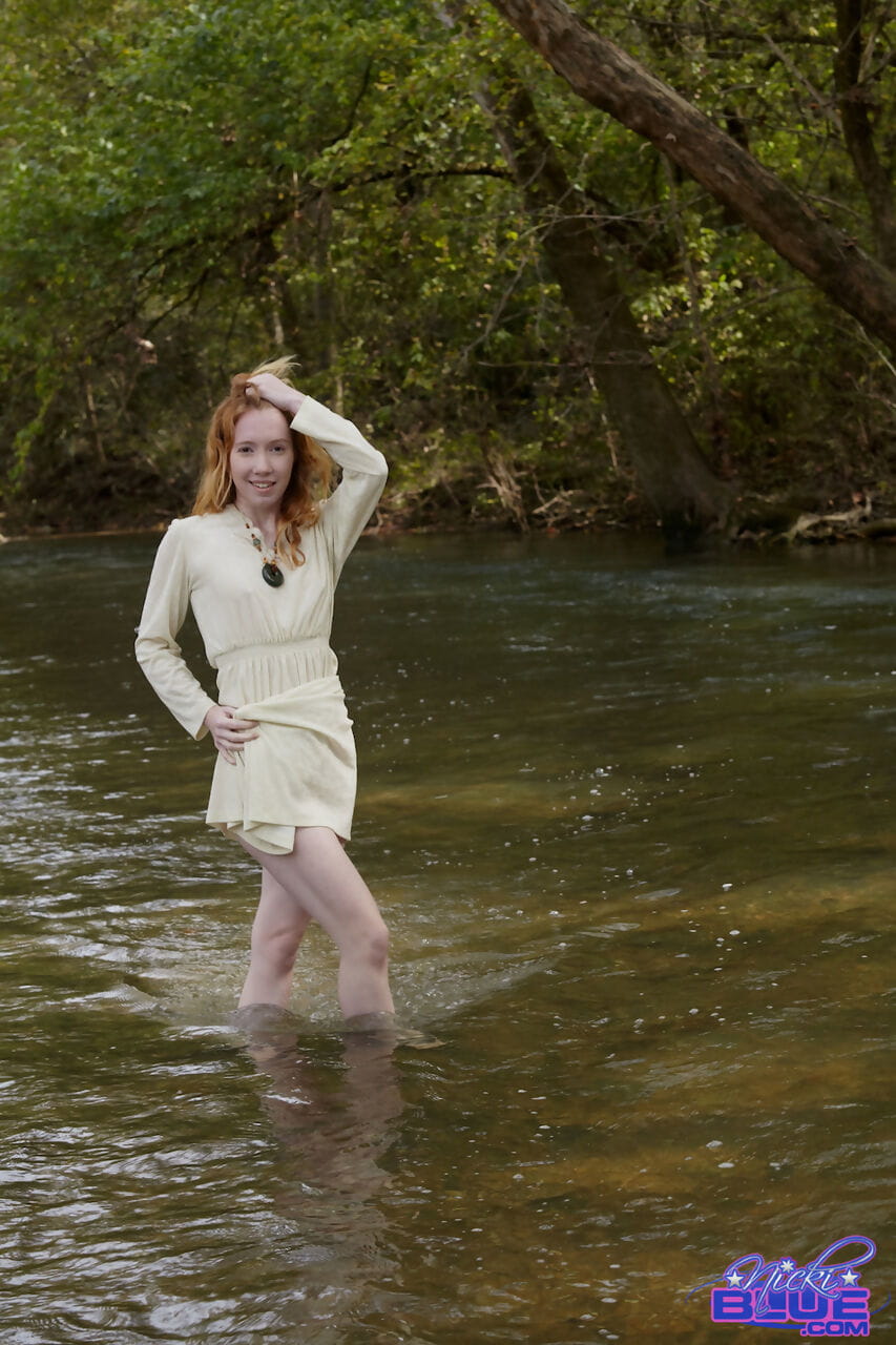 doğal kızıl saçlı Nicki MAVİ gösterir bazı bacak Süre wading içine bir sığ stream