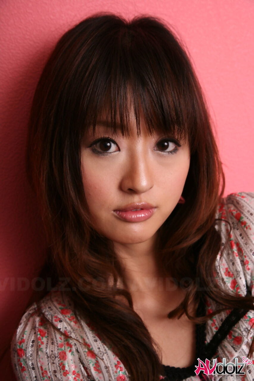 japonês modelo com um Muito rosto stands Vestido contra um Cor-de-rosa parede