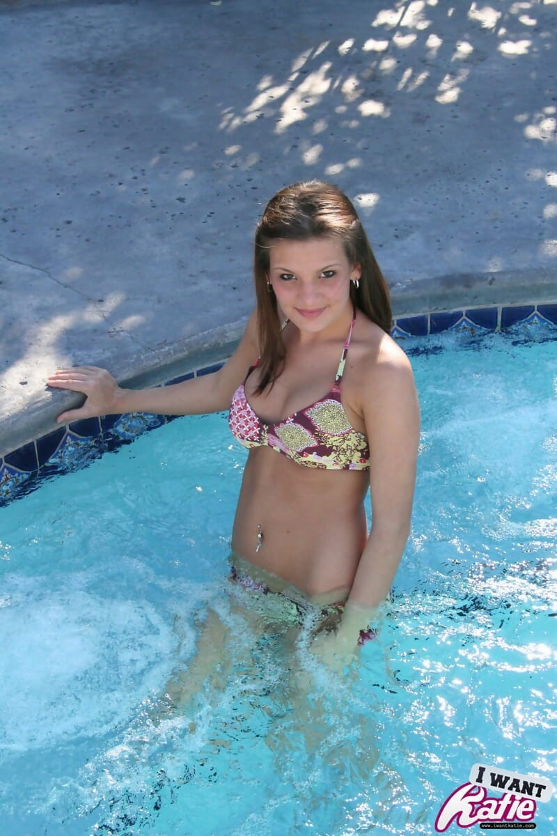 Cute teen Kate Crush covers up her bare tits after removing bikini top in pool