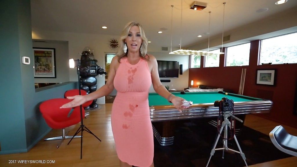 Gekleed Blond huisvrouw Sandra Otterson modellering op balkon en zwembad tabel